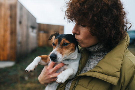 Portrait of Woman Kissing Dog Outdoors
