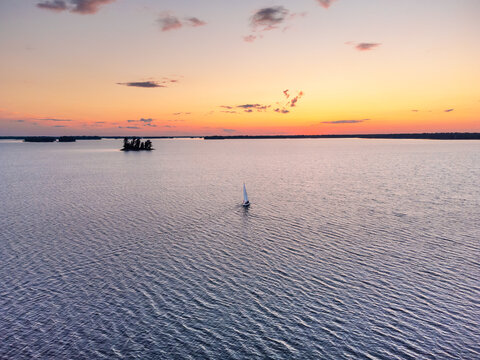 Small Sailboat Sailing into Sunset on Wilderness Lake