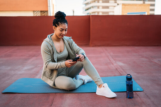 Woman in sportswear browsing smartphone during training