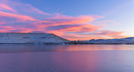 Fototapeta na wymiar Sunset Bear Creek Lake - A colorful Winter sunset view of frozen Bear Creek Lake, with Mount Carbon raising at shore. Bear Creek Lake Park, Denver-Lakewood-Morrison, Colorado, USA.