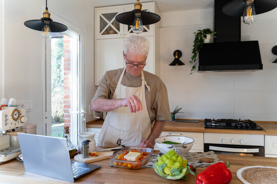Senior man cooking preparing healhty meal in kitchen