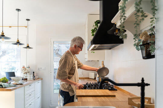 Senior man cooking preparing healhty meal in kitchen