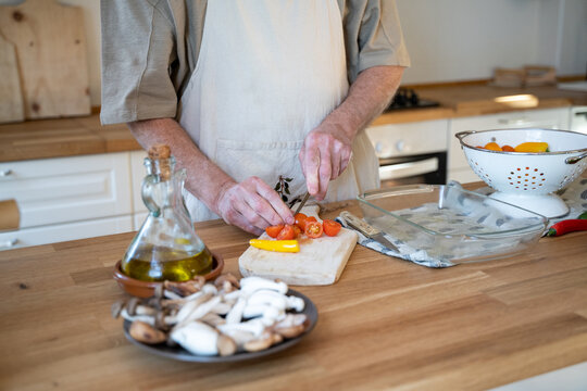 Senior man cooking preparing healhty meal in kitchen