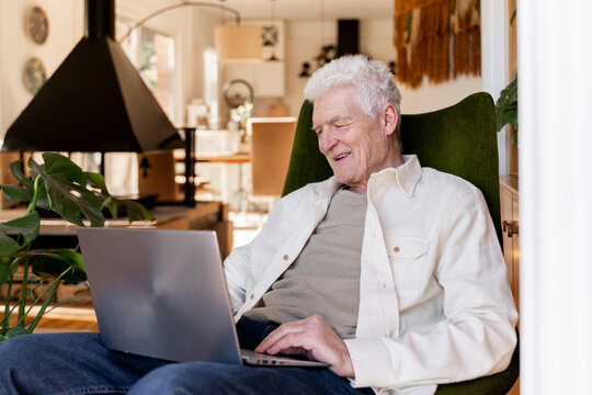 smiley Senior man making a videocall on laptop