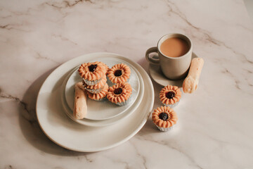Homemade cookie with jam and hot coffee on marble table in morning tone. Breakfast meal.