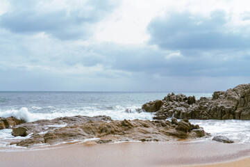 Fototapeta na wymiar High Tides Coming on to the Rocky Shores of Costa Brava in Spain, cloudy weather