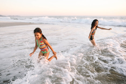 Two kids laughing and playing at the beach