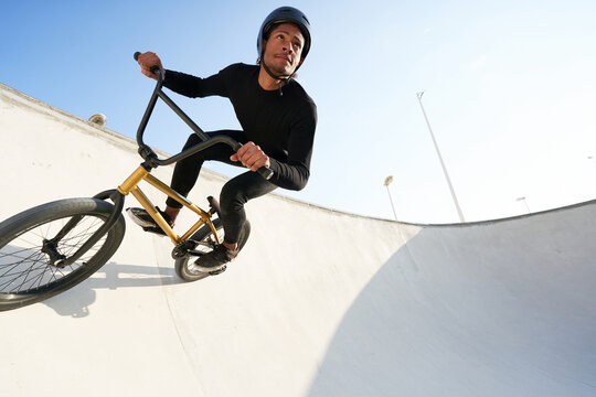 Young man riding bicycle in skate park