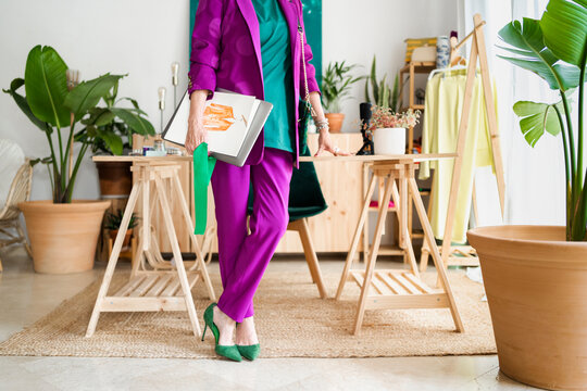 Elegant fashion designer woman holding sketches 