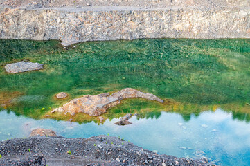 Turquoise Lake at the bottom of old Abandoned Stone Quarry