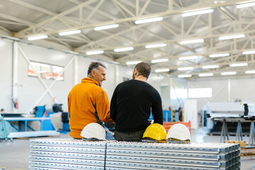 Two Workers Talking About Factory Strategy