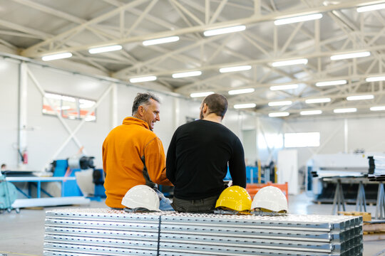 Two Workers Talking About Factory Strategy