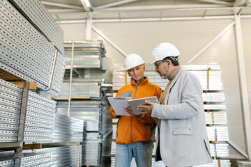 Workers Comparing Production Numbers