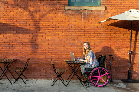 Woman in Wheelchair Enjoys Outdoor Cafe