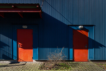 two red doors on a blue colored aluminum building 