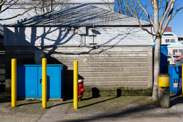 3 yellow poles and a blue box on an empty street 