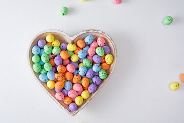 Colored easter eggs on white backdrop in the hearth shape. Flat lay minimal holiday concept. I love easter.
