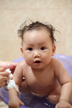 Asian baby playing in the bath

