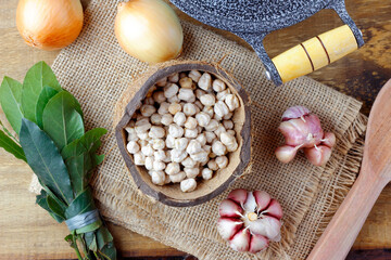 Raw organic chickpeas grains in bowl over rustic wooden table
