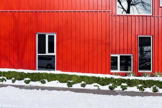 A red colored tin building with snow at the front