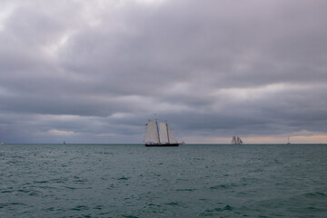 Storm clouds over the ocean with sailboat on horizon
