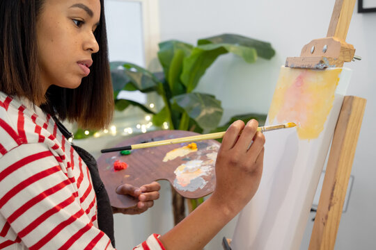 Woman painting on easel in workshop