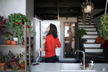 Woman at home checking the fridge