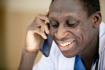 Close up African American medical male doctor talking with mobile phone.