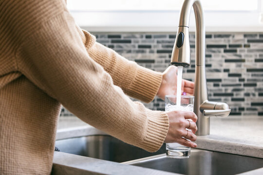 Kitchen: Woman Uses Automatic Sensor Faucet