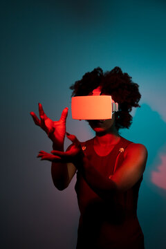 Woman using Virtual Reality glasses in a colored room