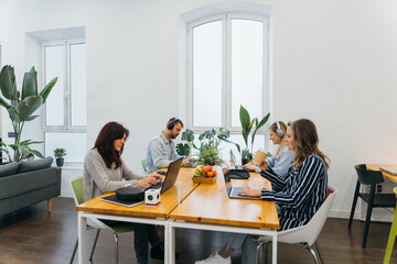 Team of colleagues working on netbooks in light office