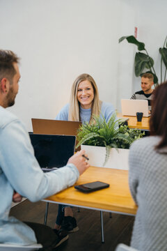 Smiling lady talking with coworkers in office