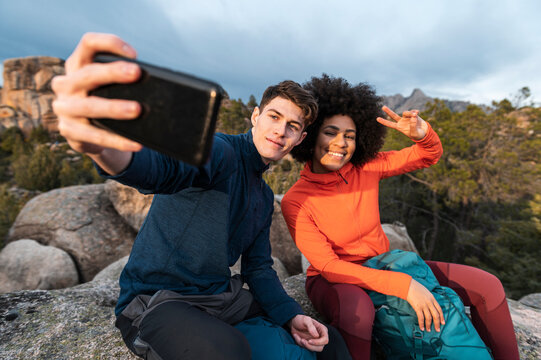 Diverse hikers using phone taking selfie 