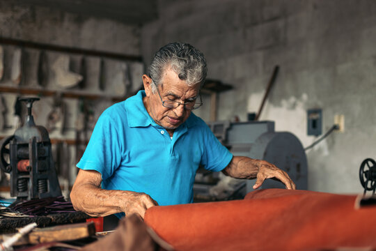 Hispanic senior shoemaker working in his workshop