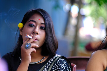 Young woman smoking cigarette at outdoors at daytime