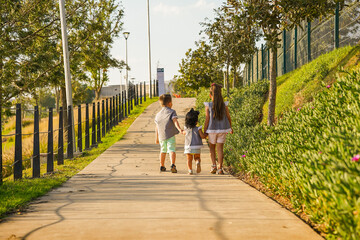  niños felices hermanos amigos juntos caminando tomados de la mano en el parque disfrutando de su...