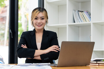 Asian businesswoman using the laptop and working at the modern desk and paperwork Asian woman planning financial report analysis business plan investment financial analysis concept