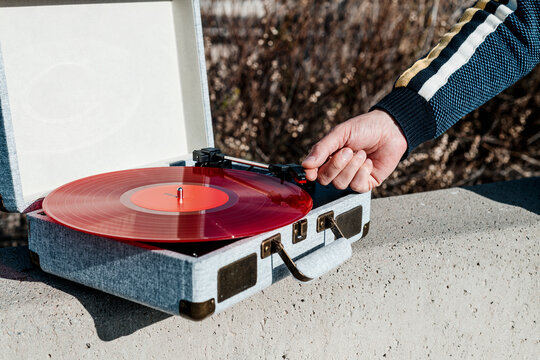 plays a disc in a portable turntable outdoors