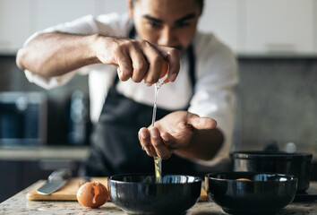 Pastry chef separating the egg yolks