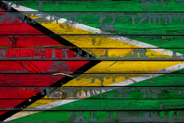 The national flag of Guyana is painted on uneven boards. Country symbol.