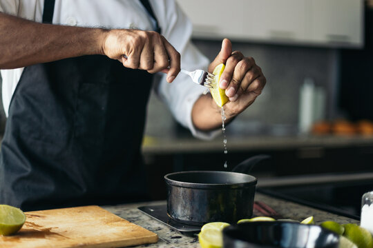 Anonymous pastry chef squeezing a lemon