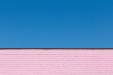 Pink brick wall with blue sky in the background