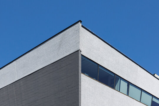 The corner of a gray and white building 