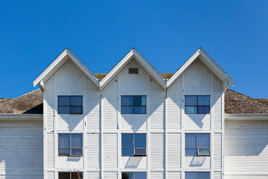 Old white wooden house with triangular roof 
