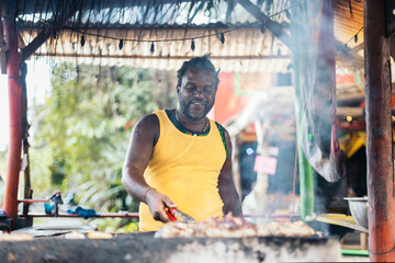 Afro-Caribbean man cooking on a barbeque