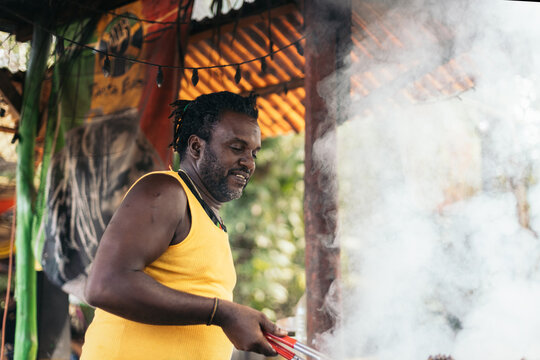 Afro-Caribbean man cooking on a barbeque