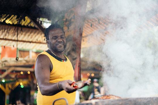 Afro-Caribbean man cooking on a barbeque