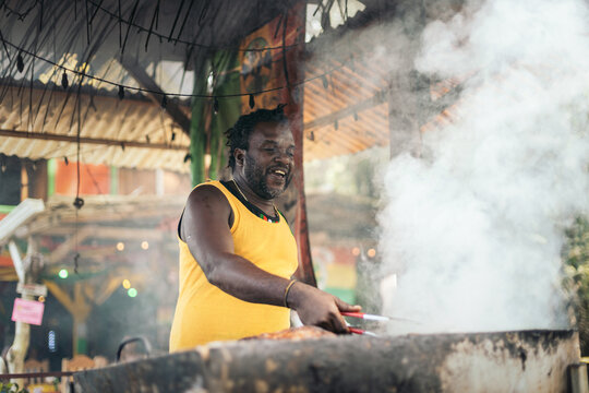 Afro-Caribbean man cooking on a barbeque