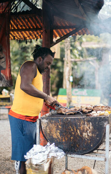 Afro-Caribbean man cooking on a barbeque