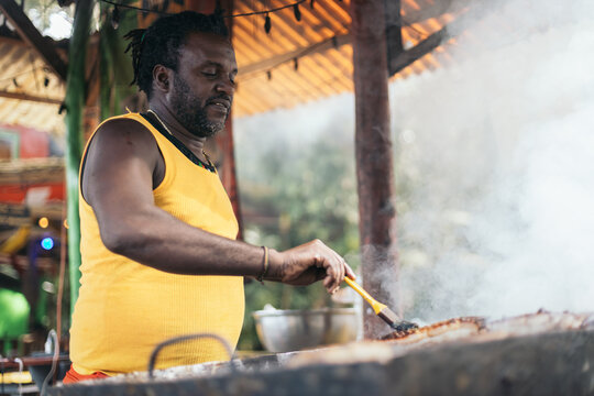 Afro-Caribbean man cooking on a barbeque